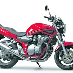 Czerwony motocykl Suzuki GSF 600 Bandit, klasyczny naked bike z widocznym silnikiem i chromowanym wydechem, gotowy na przygodę.