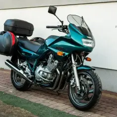 Zielony motocykl Yamaha XJ 900 z kuframi, gotowy na dalekie podróże.