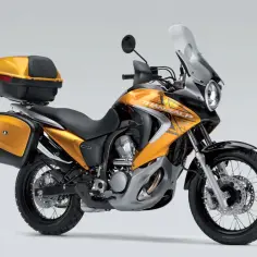 Złoty motocykl Honda Transalp 700 z kuframi. Dane techniczne tego modelu są imponujące.