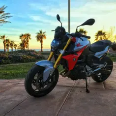 BMW F 900 R na tle palem i zachodzącego słońca. Idealny motocykl na wakacyjne przejażdżki.