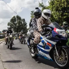 Kolumna motocykli w zabawnych strojach jedzie ulicą.