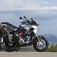 Srebrny motocykl Aprilia Caponord 1200 na tle górskiego krajobrazu. Poznaj jego aprilia caponord 1200 dane techniczne.