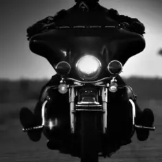 Motocyklista na drodze, światła motocykla rozświetlają mrok. To obraz wolności i przestrzegania zasad, jak w gremium MC.