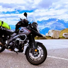 Szary Suzuki V-Strom, najlepszy motocykl turystyczny, gotowy na przygodę wśród alpejskich szczytów.
