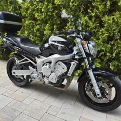 Czarny motocykl Yamaha Fazer 600 z kufrem, idealny na długie trasy. Sprawdź jego dane techniczne!