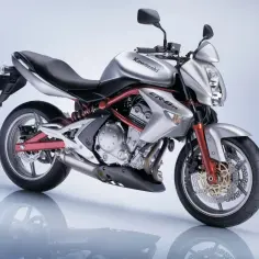 Srebrny motocykl Kawasaki ER-6n z czerwonym stelażem i detalami, prezentowany na błyszczącej powierzchni.