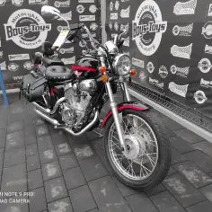 Czarny motocykl Lifan 250 z czerwonymi akcentami i sakwami, gotowy na przygodę.