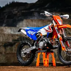 Pomarańczowy motocykl KTM gotowy do jazdy po wyboistym terenie. Firma KTM słynie z produkcji mocnych maszyn.