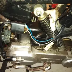 Silnik motoroweru z widocznym modułem zapłonowym i świecą. Brak iskry przyczyny może tkwić w tym układzie.