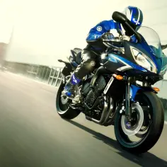 Motocyklista w niebieskim kombinezonie na Yamasze FZ6, pędzący z imponującym przyspieszeniem 0-100.