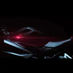 Ciemny motocykl sportowy Honda CBR 250RR z czerwonym akcentem świetlnym.
