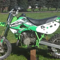 Zielony Kawasaki KX 65, idealny dla młodych adeptów motocrossu. Ile ma koni? To zależy od wersji, ale ten model to świetna zabawa!