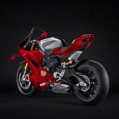 Czerwony motocykl Ducati V4R z błyszczącym, srebrnym bakiem paliwa, prezentujący swoje sportowe linie na czarnym tle.