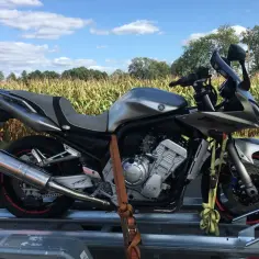 Srebrny motocykl Yamaha na przyczepce, gotowy do podróży przez czeskie strony z motocyklami.