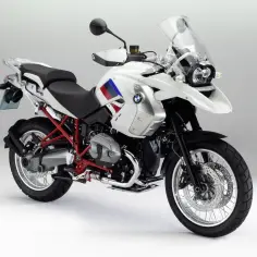 Biały motocykl BMW R1200GS z czerwonym stelażem i flagą na baku. Na co zwrócić uwagę: opony, felgi, silnik, siedzenie, owiewka.