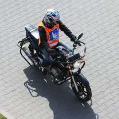 Motocyklista w kamizelce z literą "L" ćwiczy jazdę na motocyklu o mocy 35kW.
