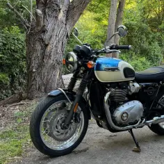 Klasyczny motocykl Triumph Bonneville T120 w dwukolorowym malowaniu, gotowy na przygodę. Dane techniczne są imponujące.
