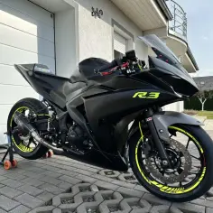 Czarny matowy Yamaha R3 z neonowymi akcentami, gotowy do jazdy. Wygląda jak mniejszy brat V Max, ale zwinność R3 jest niezaprzeczalna.
