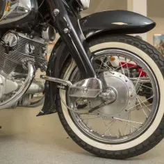 Błyszczący silnik i białe opony klasycznego motocykla Honda Dream 125.