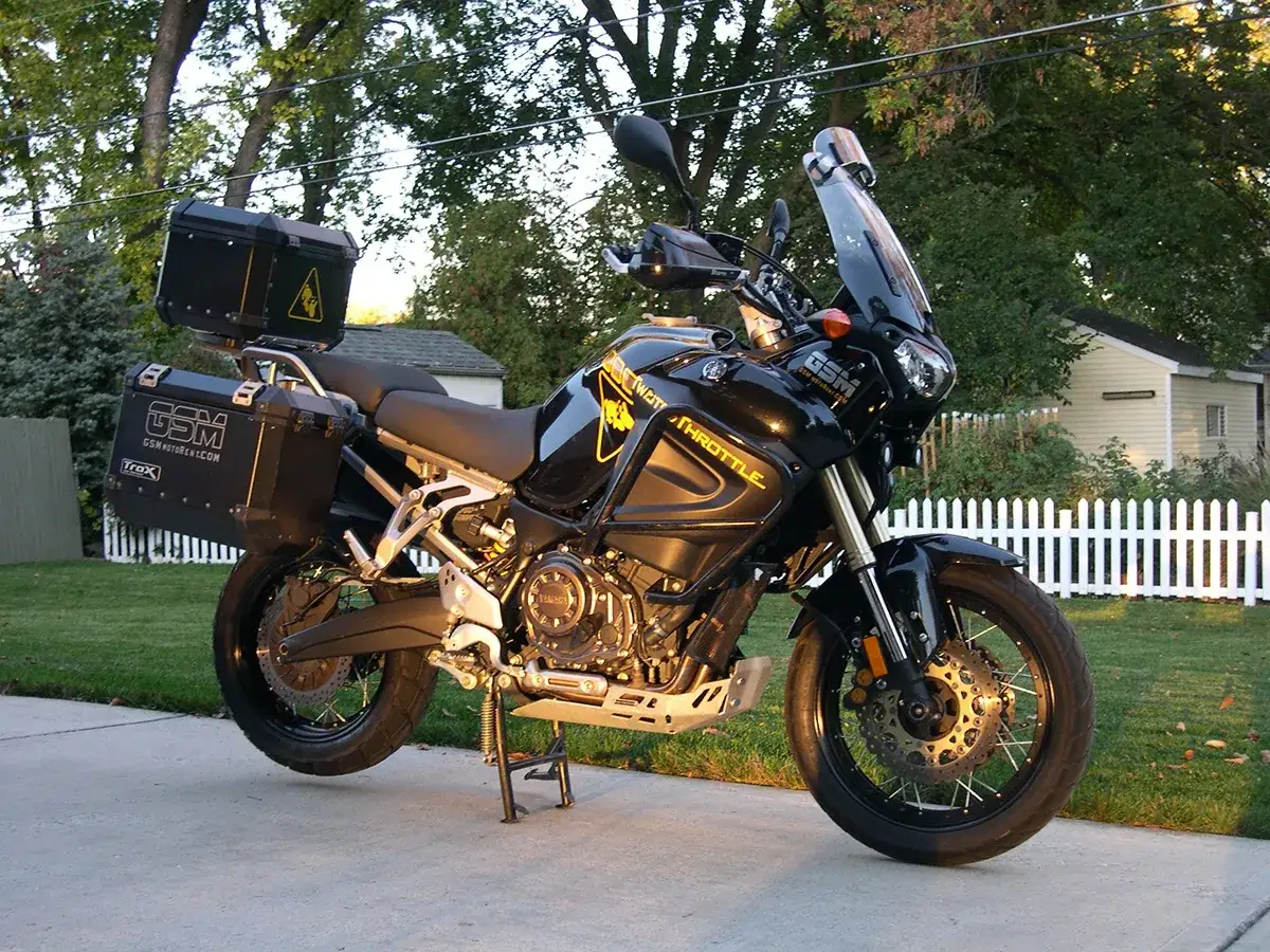 Czarny motocykl szosowo turystyczny z kuframi, gotowy na dalekie podróże.