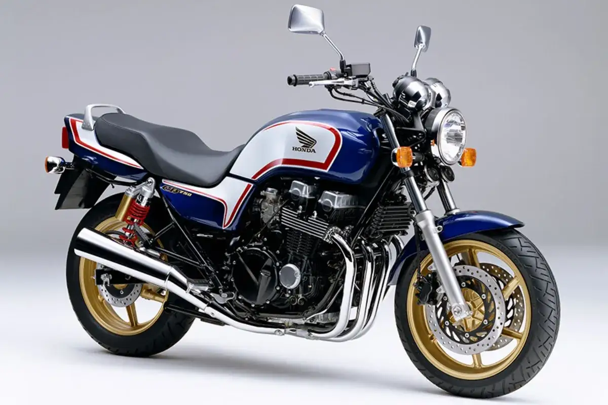 Klasyczny motocykl Honda CB750 Nighthawk w kolorze granatowym z białymi i czerwonymi pasami, ze złotymi felgami.