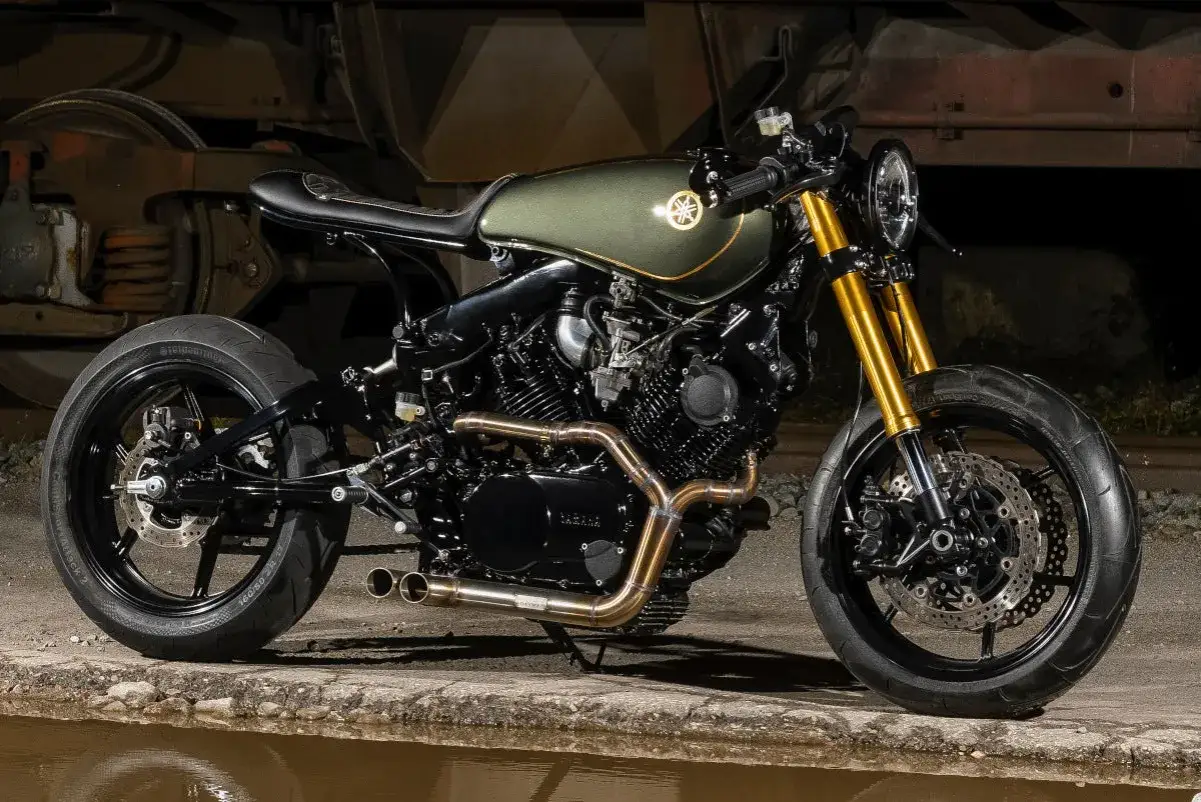 Stylowy caferacer w kolorze oliwkowym, z błyszczącym złotym wykończeniem, gotowy na nocną przejażdżkę.