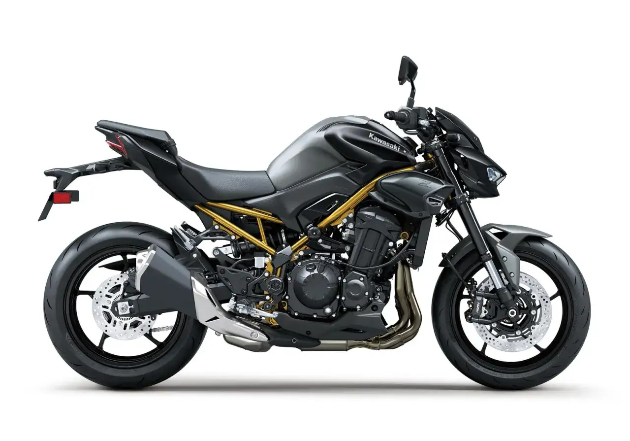 Czarny motocykl Kawasaki Z900 z widoczną złotą ramą i sportowym wydechem.