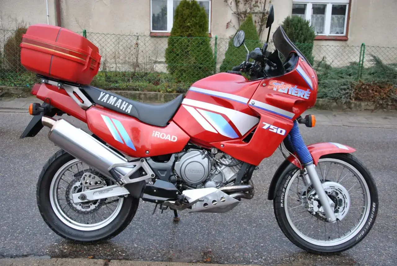 Czerwony motocykl Yamaha XTZ 750 Super Ténéré z kufrem. Dane techniczne tego modelu to jego moc i wszechstronność.