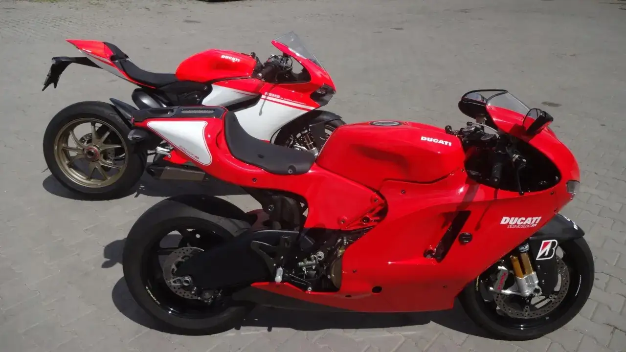 Dwa czerwone motocykle Ducati Desmosedici RR stoją obok siebie na bruku.