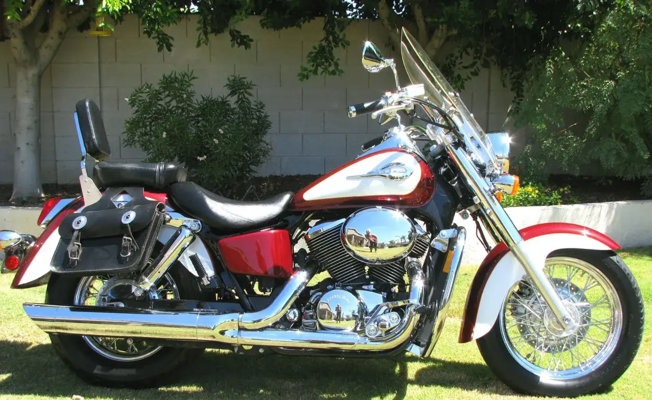 Honda Shadow 750 dane techniczne: stylowy motocykl z chromowanymi elementami, skórzaną sakwą i dużą szybą.