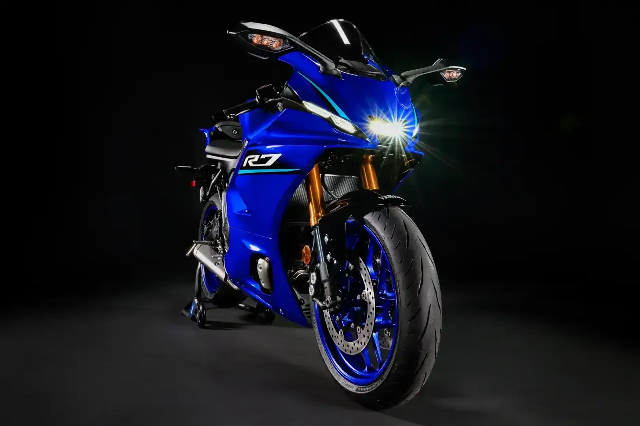 Niebieski motocykl sportowy Yamaha R7 z włączonymi światłami. Szczegółowe yamaha r7 dane techniczne dostępne w opisie.