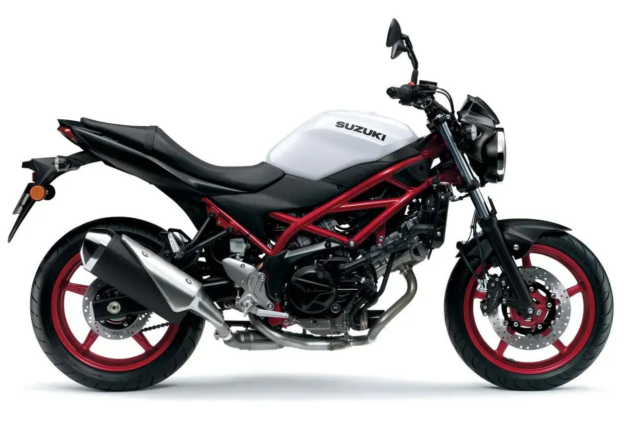 Suzuki SV 650S z białym bakiem i czerwonym stelażem, gotowy na podbój dróg.