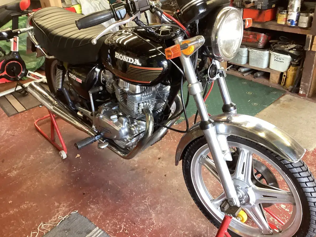 Klasyczny motocykl Honda CB250T Dream, lśniący chromem i czarnym lakierem, gotowy do jazdy.