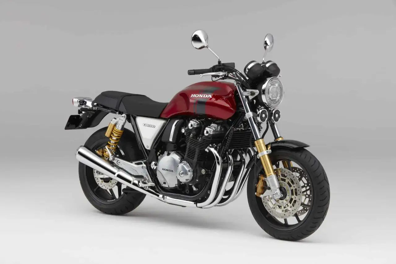 Czerwony motocykl Honda CB1100 z czarnymi pasami, klasyczny design, jeden z wielu znanych marek motocykli.