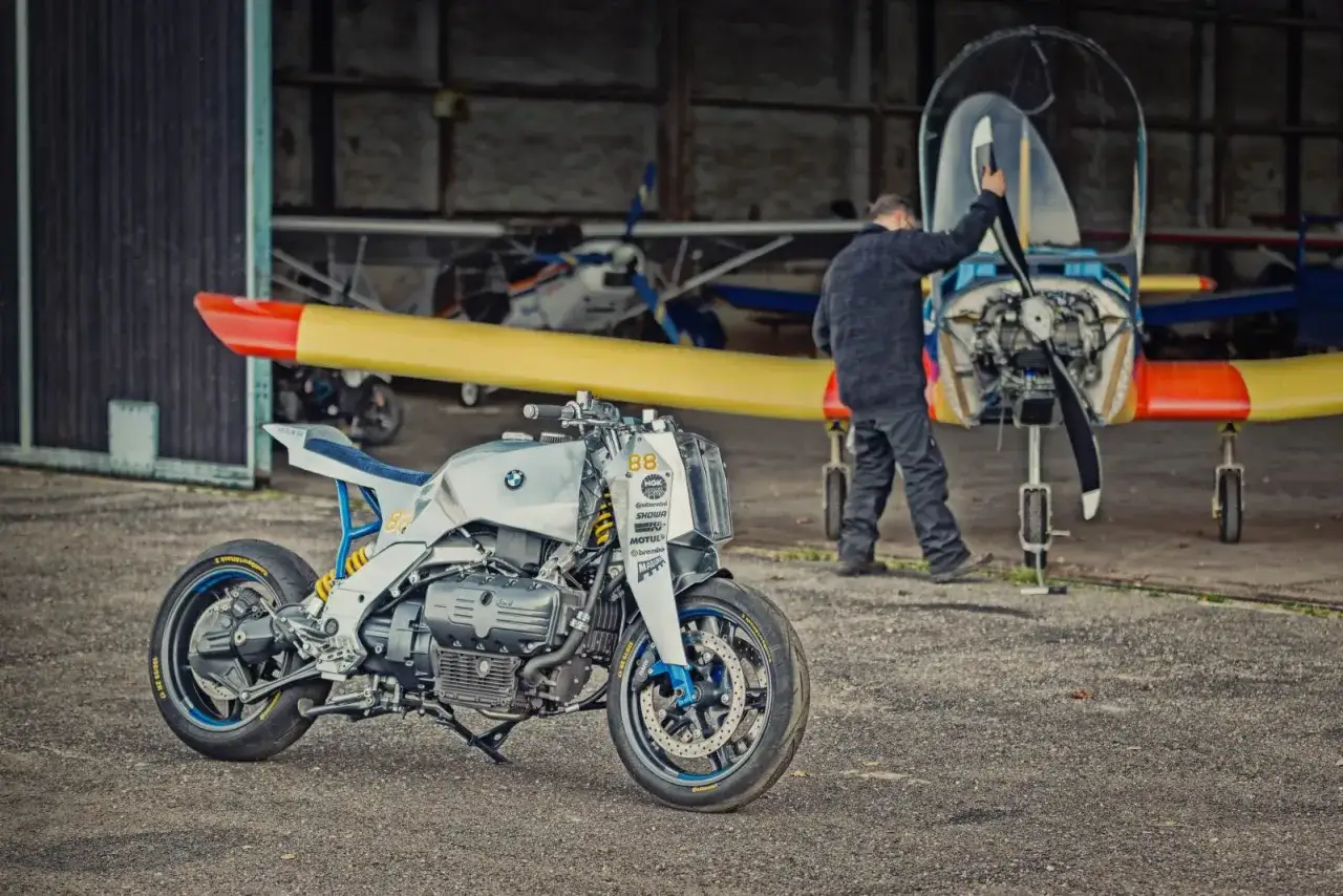 Zmodyfikowany BMW K1200RS, który mimo swoich wad, wygląda świetnie obok samolotu.