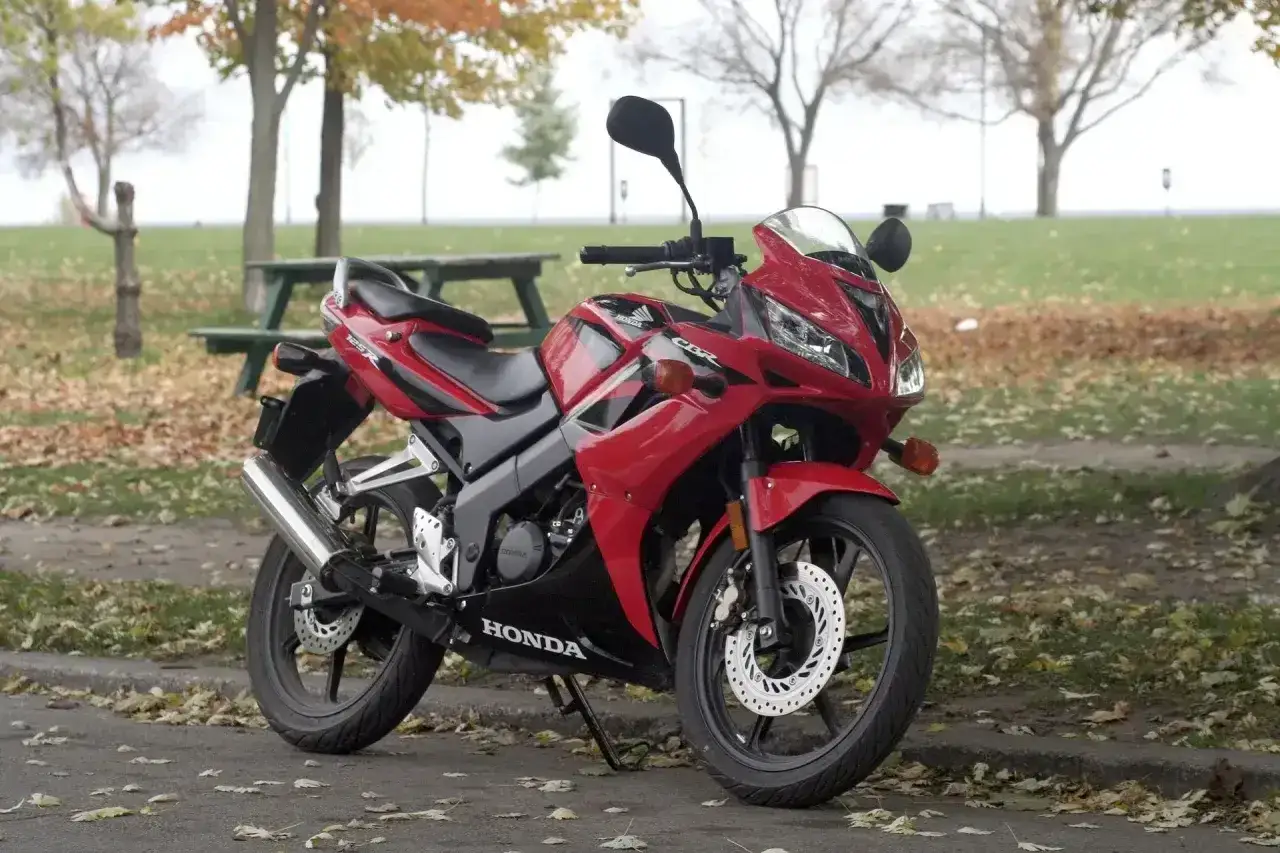 Czerwona Honda CBR 125R, gotowa do jazdy, z widocznym napisem 