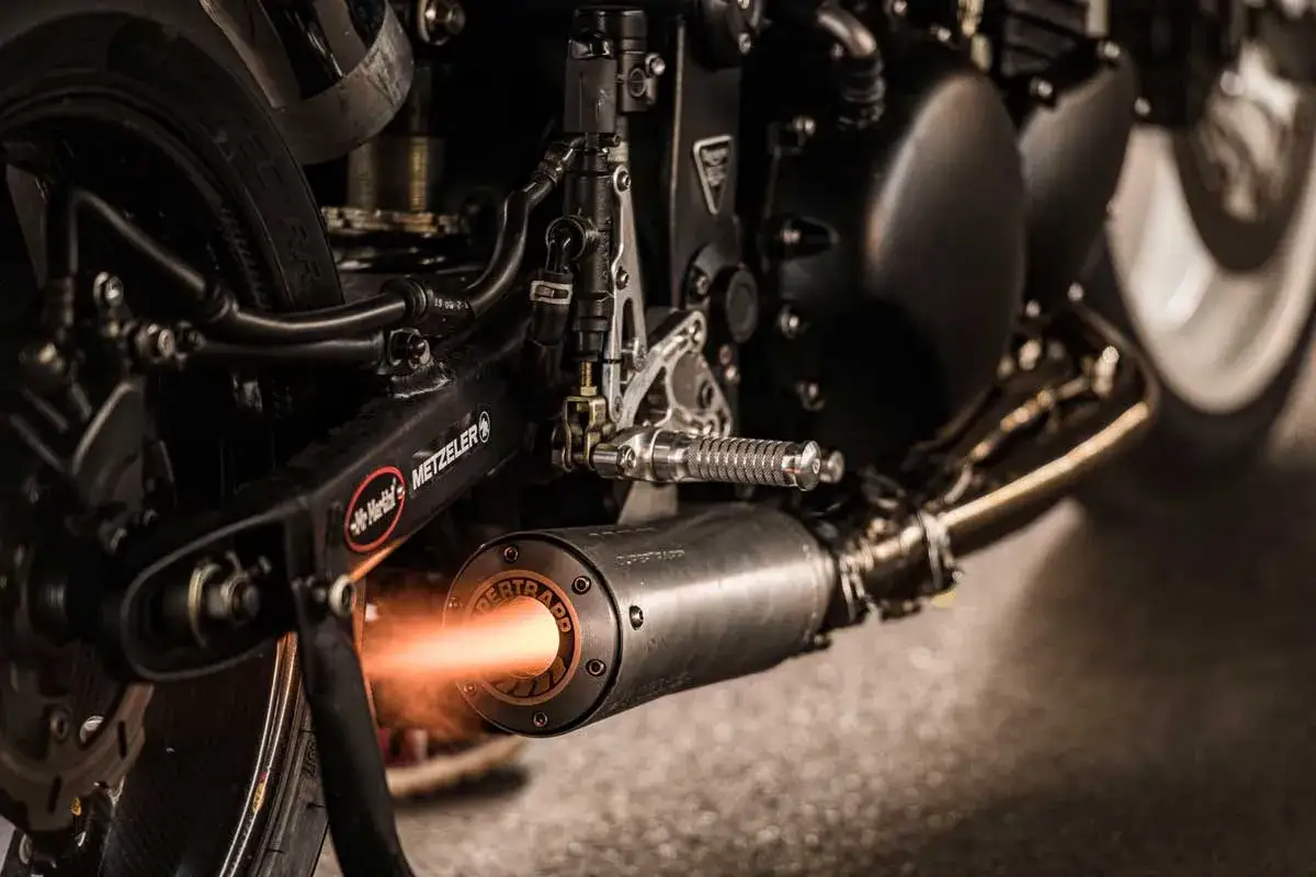 Płomień wydobywa się z tłumika motocykla, gdzie układ dolotowy zapewnia moc.