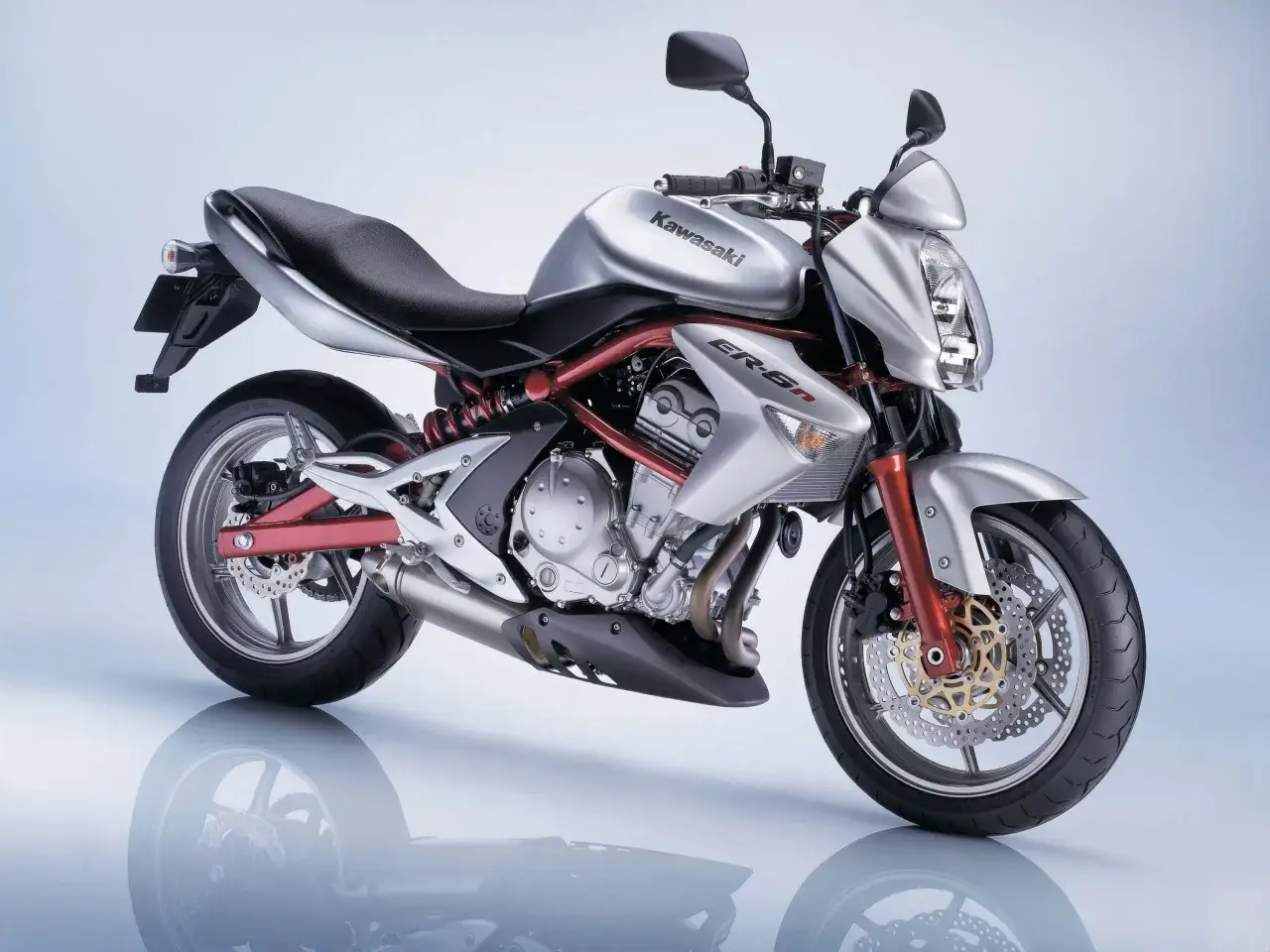 Srebrny motocykl Kawasaki ER-6n z czerwonym stelażem, gotowy do jazdy.
