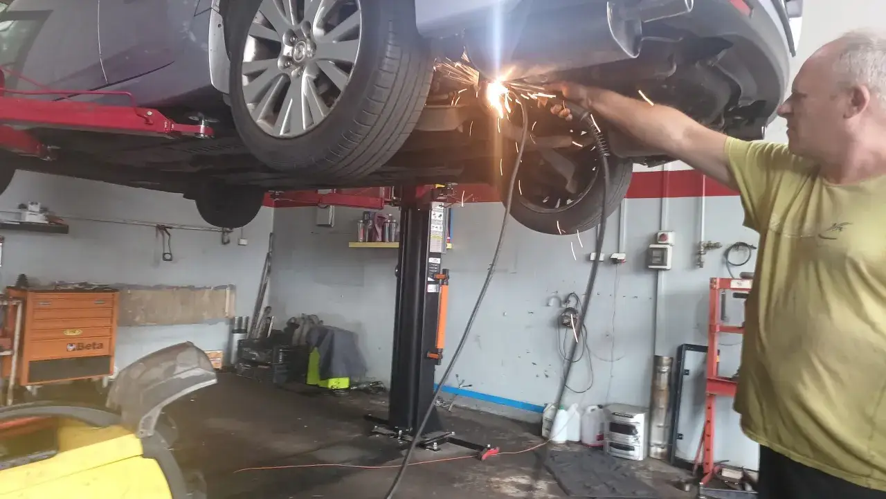 Mechanik spawa układ wydechowy, być może w celu usunięcia objawów nieszczelności.