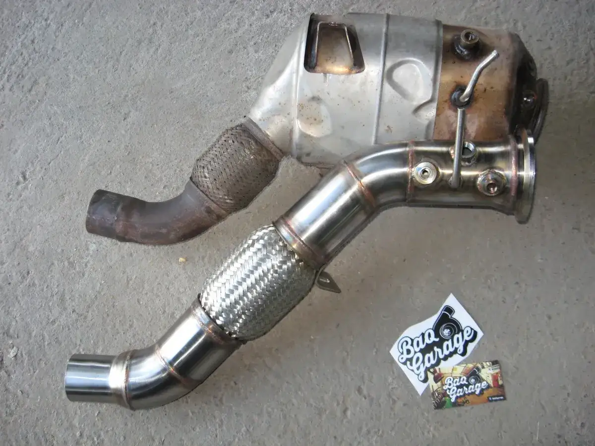 Nowy, błyszczący downpipe obok starego, zardzewiałego. Zobacz, co daje downpipe dla lepszego przepływu spalin i mocy silnika.